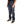 Person wearing dark blue jeans and black shoes on a white background