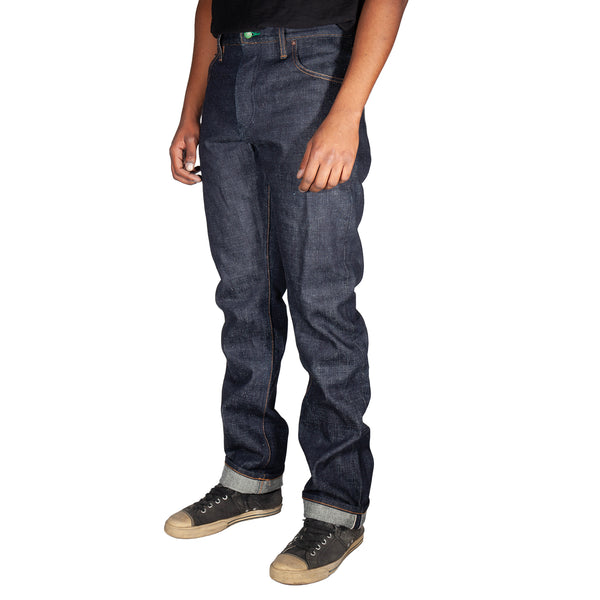 Person wearing dark blue jeans and black shoes on a white background