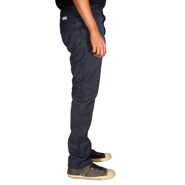 Person wearing dark blue jeans and black sneakers on a white background