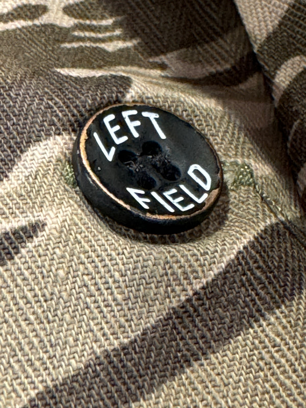 Black button with 'LEFT' text on a camouflage fabric background