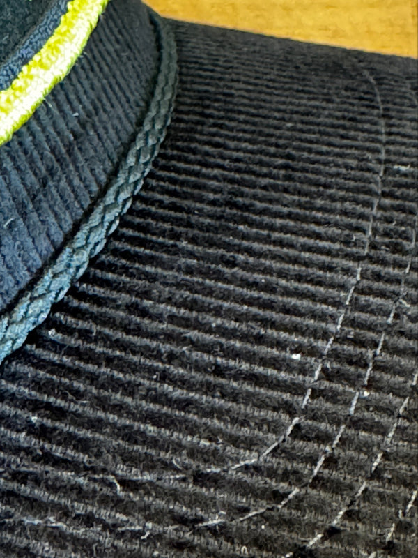 Close-up of a textured black fabric surface with a visible seam.