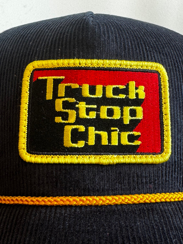 Black cap with 'Truck Stop Chic' logo on a white background