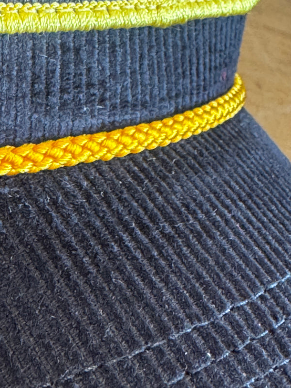 Close-up of a textured fabric with yellow trim on a wooden surface