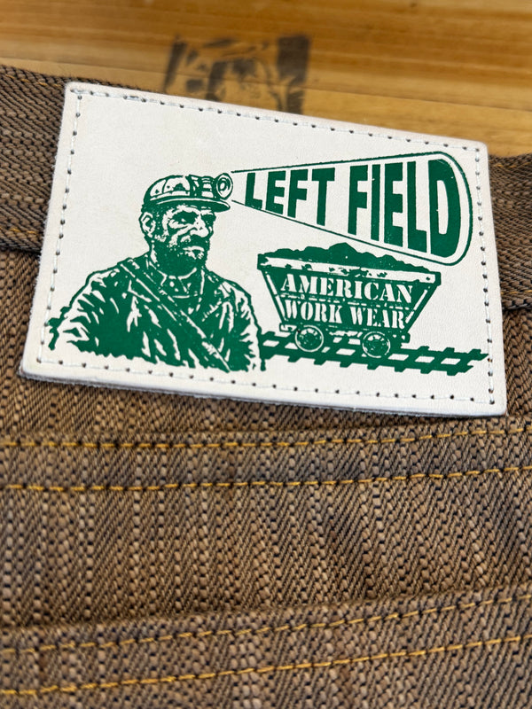 Green and white patch with text and graphics on a textured surface