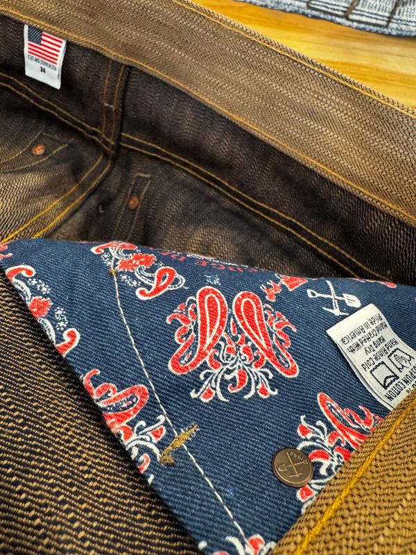 Close-up of a denim pocket with floral pattern and brand label on a jacket.