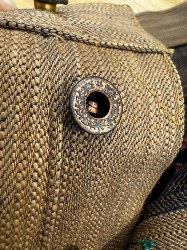 Close-up of a textured fabric surface with a decorative button.