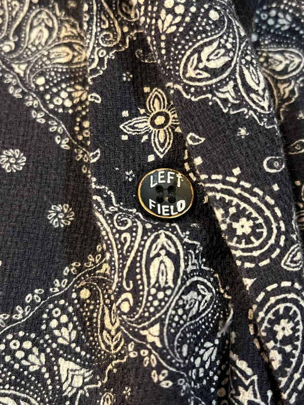 Close-up of a black and white patterned shirt with a 'LEFT FIELD' button.