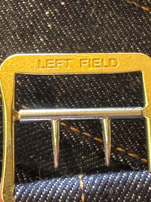 Close-up of a gold buckle on a textured fabric background