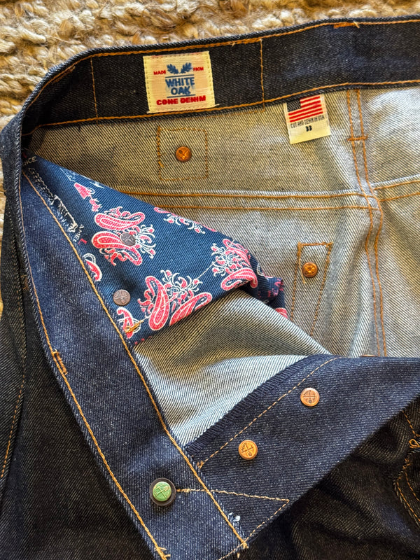 Close-up of a denim jacket with bandana lining and brand labels.