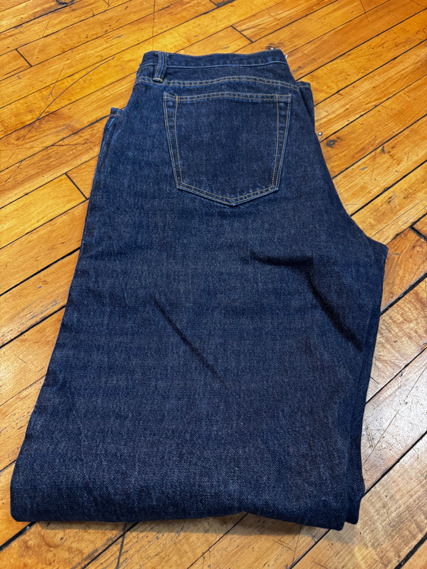 Folded blue jeans on a wooden floor