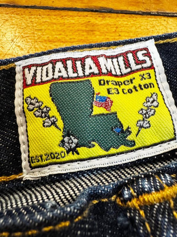 Label on denim fabric with 'Vidalia Mills' branding and a map of Louisiana.