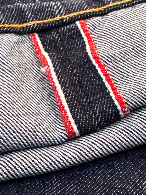 Close-up of denim fabric with red stitching detail