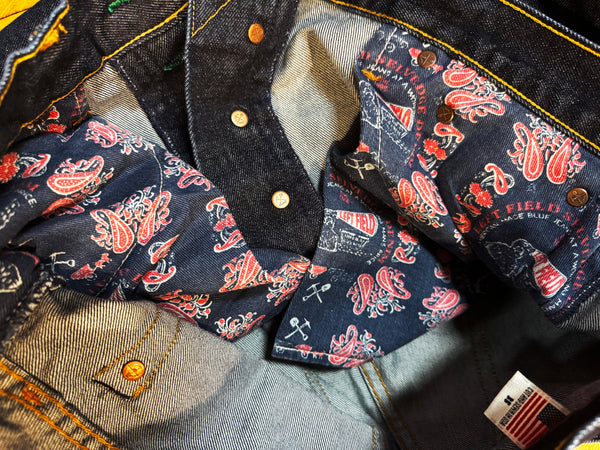 Close-up of a denim jacket with paisley pattern and brand label.