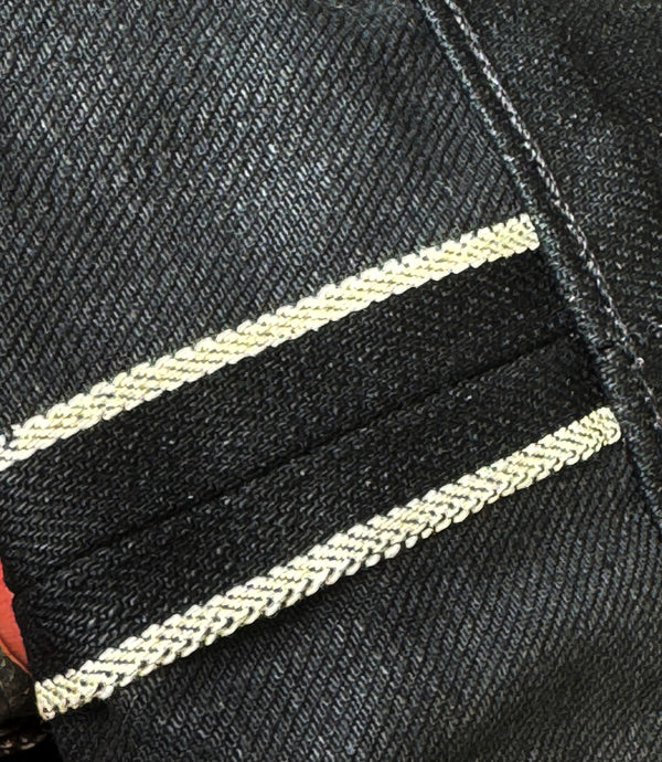 Close-up of black denim fabric with white stitching detail