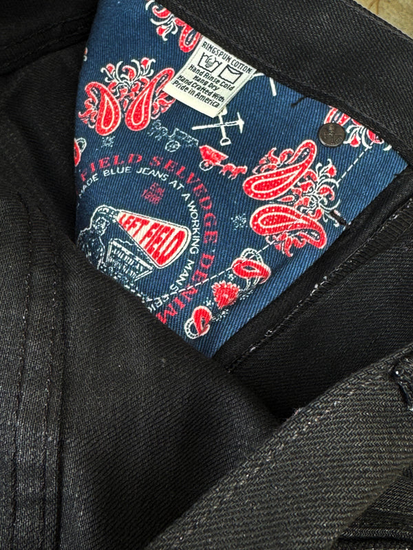 Close-up of a branded label on a black garment with red and white designs.