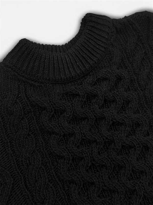 Close-up of a black knitted sweater with a textured pattern.