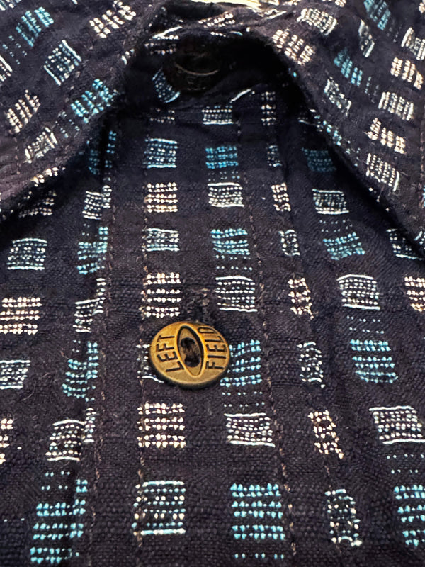 Close-up of a patterned shirt with a gold button