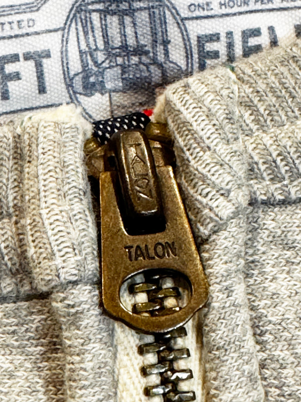 Close-up of a Talon zipper pull on a textured fabric background