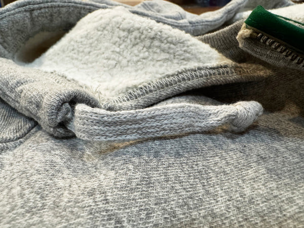 Folded gray sweater on a surface