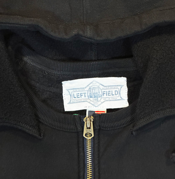 Close-up of a black sweatshirt with a Left Field label on the collar.