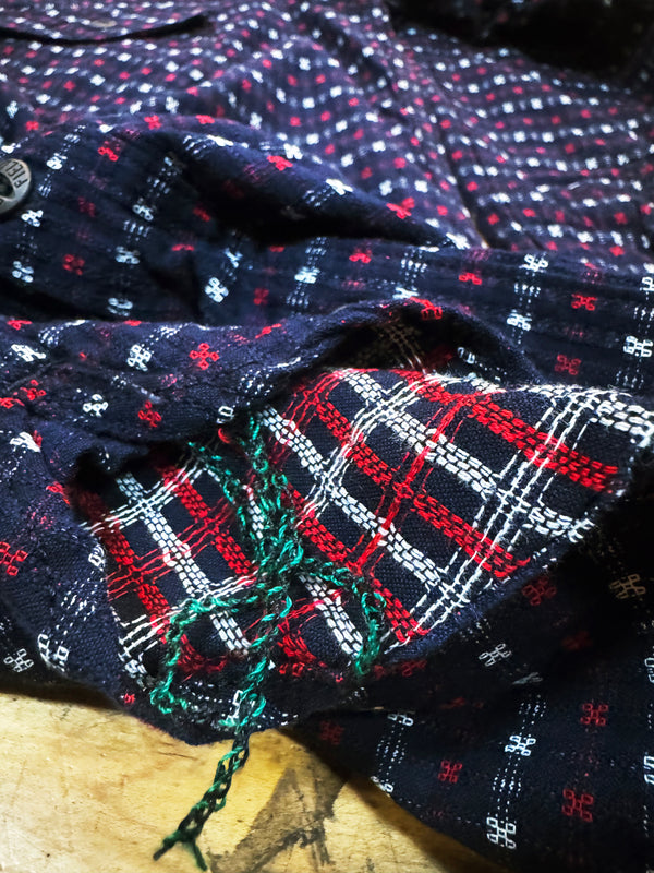 Close-up of patterned fabric with red, white, and blue colors on a wooden surface.