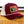 Maroon and beige trucker hat with 'Truck Stop Chic' logo on a wooden surface