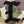 Close-up of a camouflage fabric patch with a large dark brown embroidered letter 'I'.