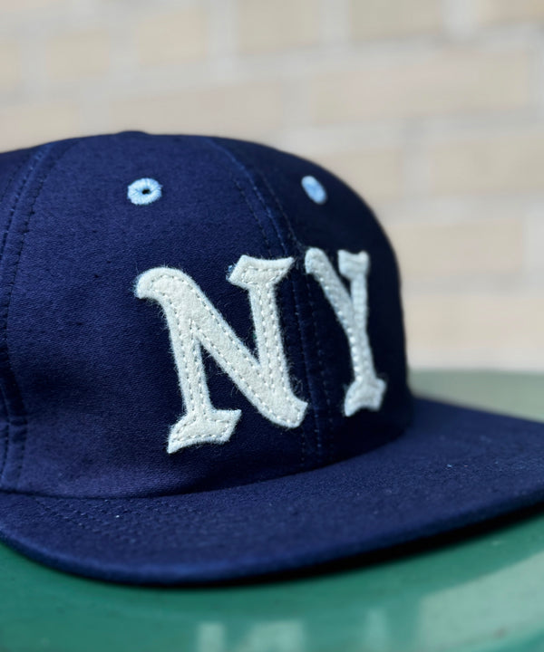 Navy blue cap with 'NY' logo on a blurred background