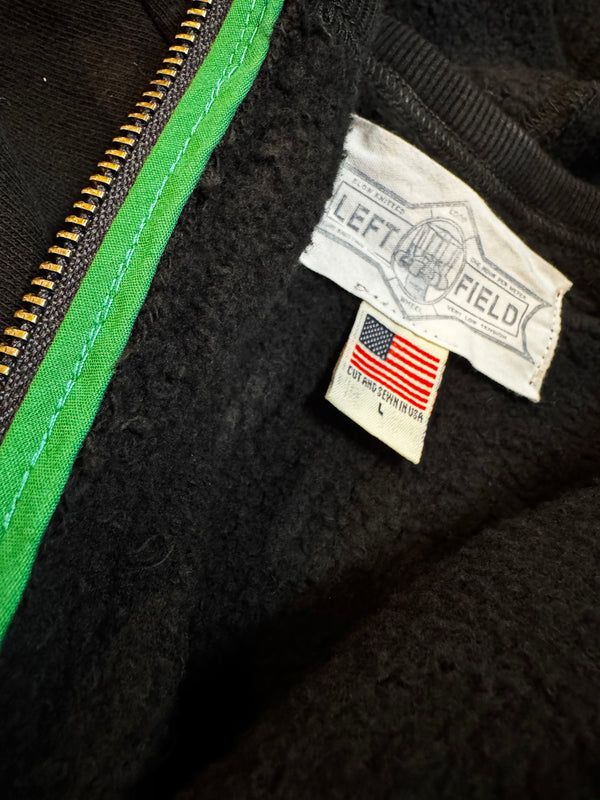 Close-up of a black jacket with a Left Field label and American flag patch.
