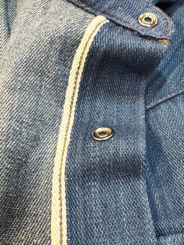 Close-up of a blue denim shirt with buttons and stitching details.