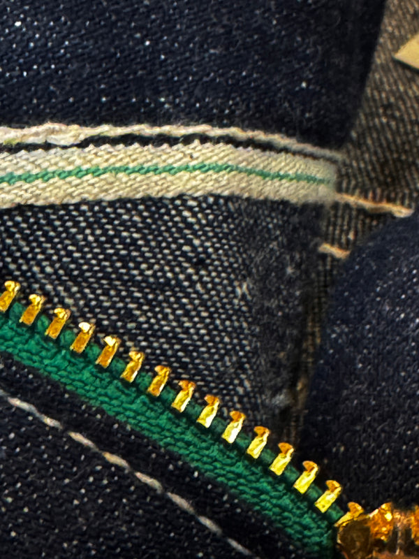 Close-up of a zipper on a piece of denim fabric.