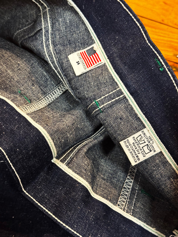 Close-up of a denim jacket with brand labels on a wooden surface