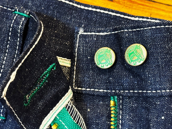 Two green pins on a denim fabric background